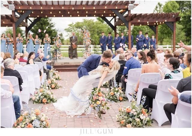 A bride and groom kissing in front of their wedding guests