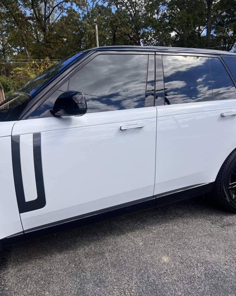 White Range Rover with black accents, parked outdoors with tinted windows.