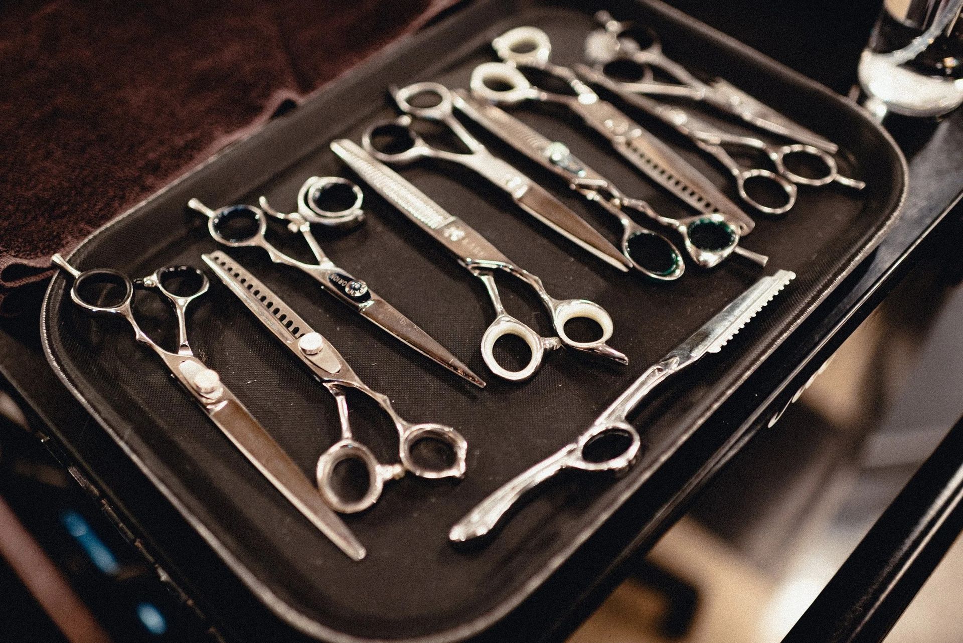 Tray of various hairdressing scissors, some with notched blades.