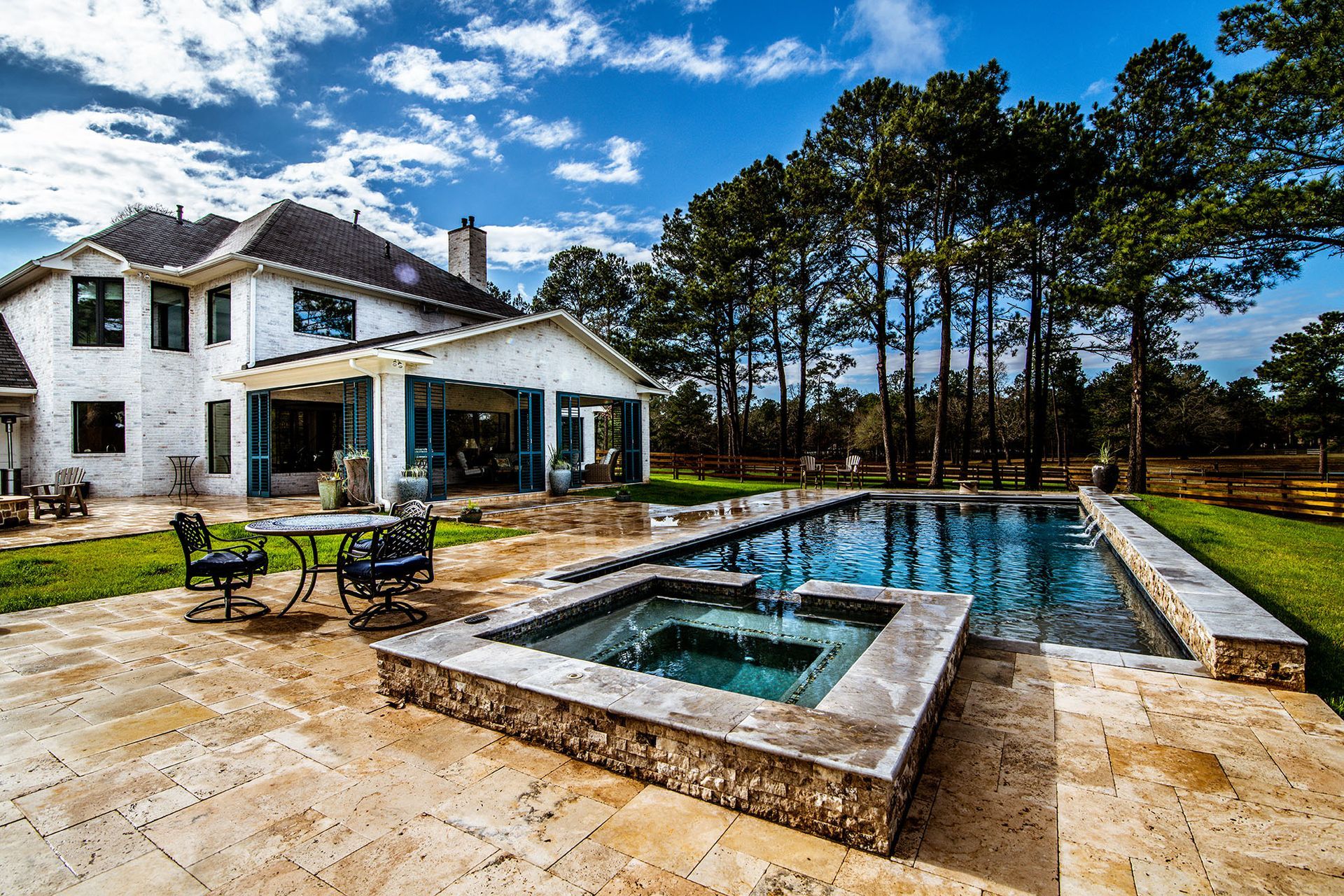 Luxury home with swimming pool, spa, and patio on a sunny day.