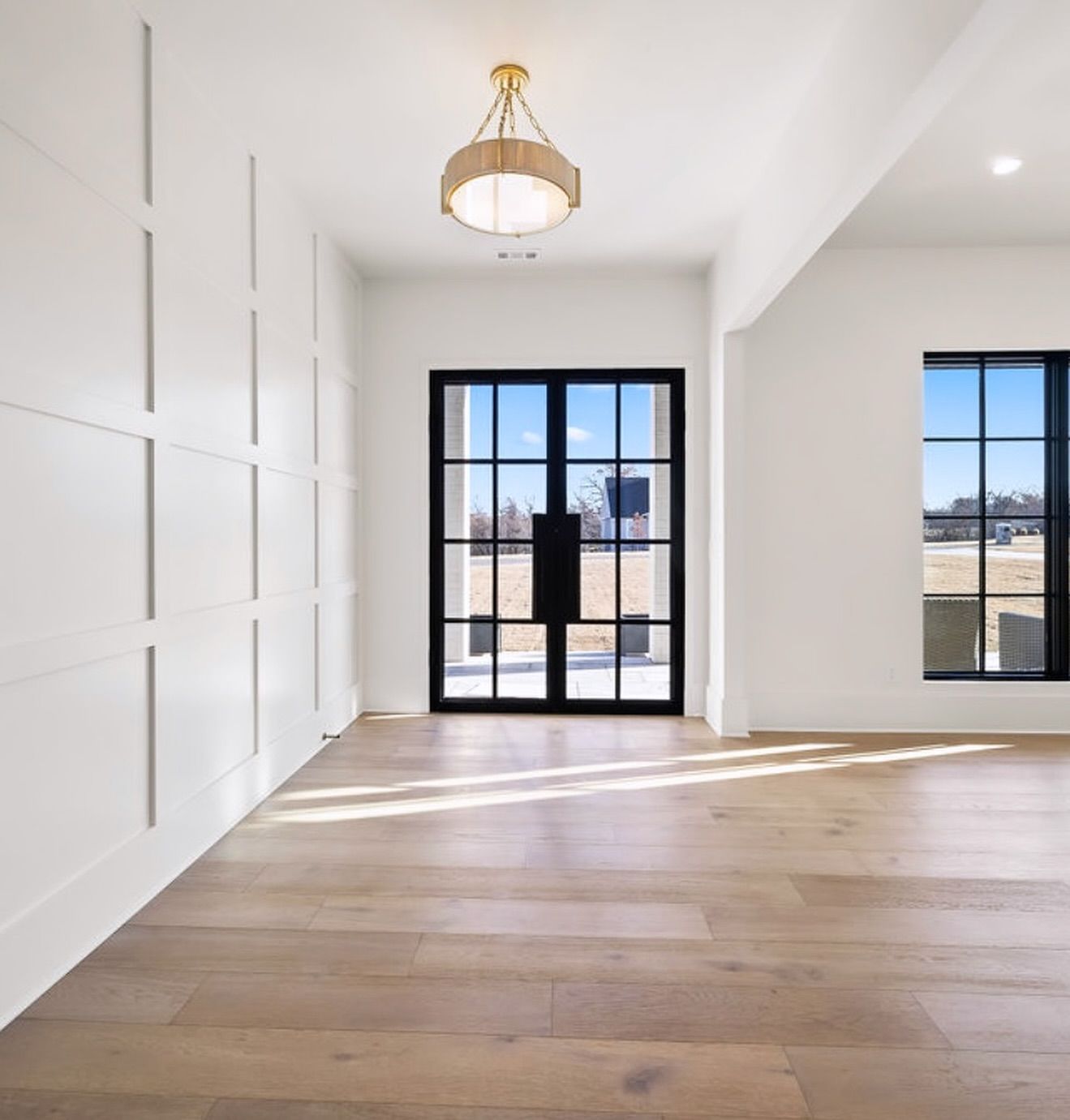 An empty room with hardwood floors and white walls
