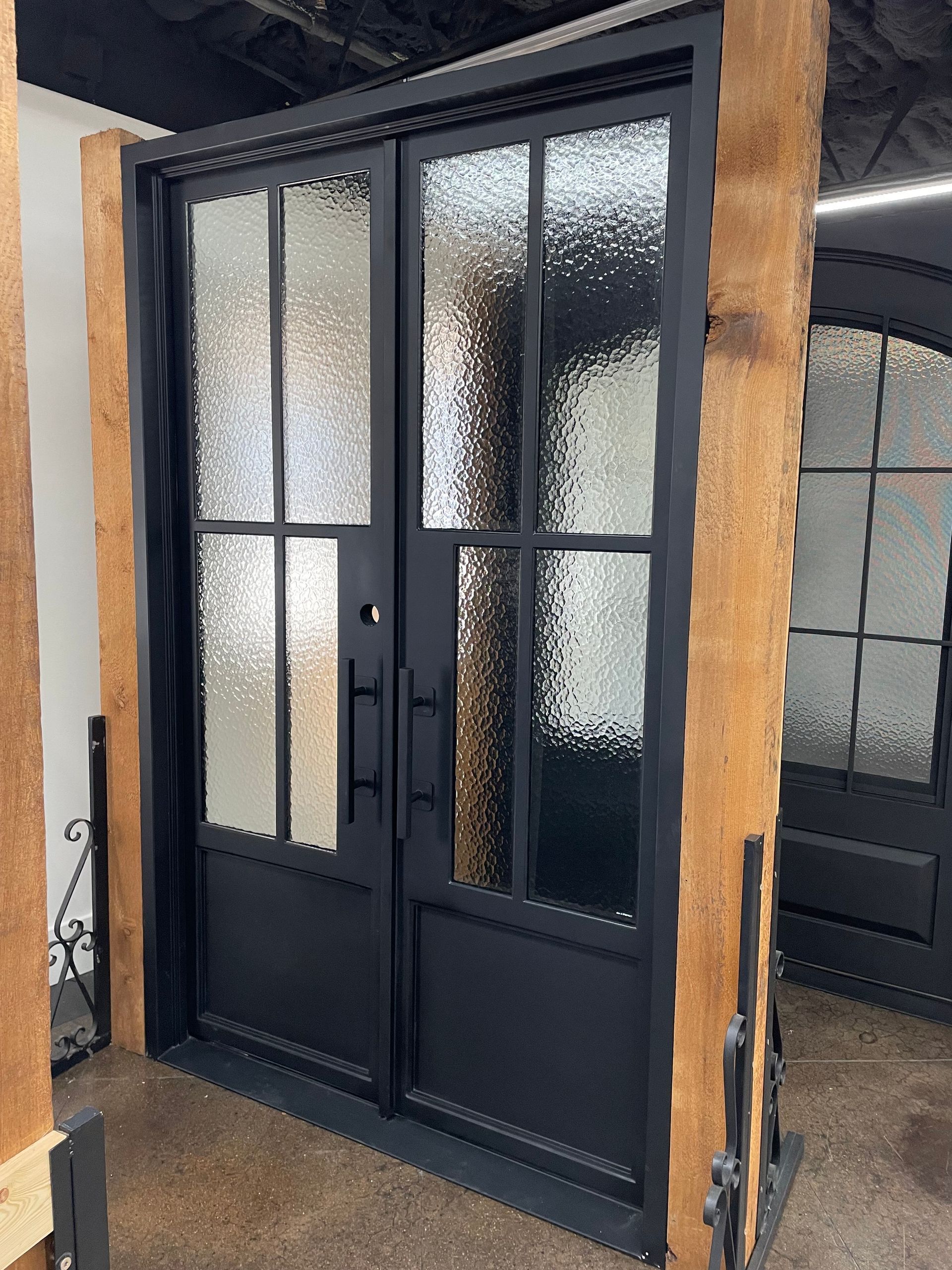 A pair of black doors with clear glass in a room.