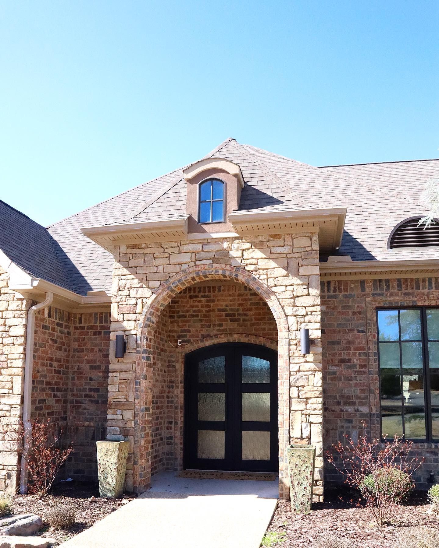 The front of a brick house with a black door