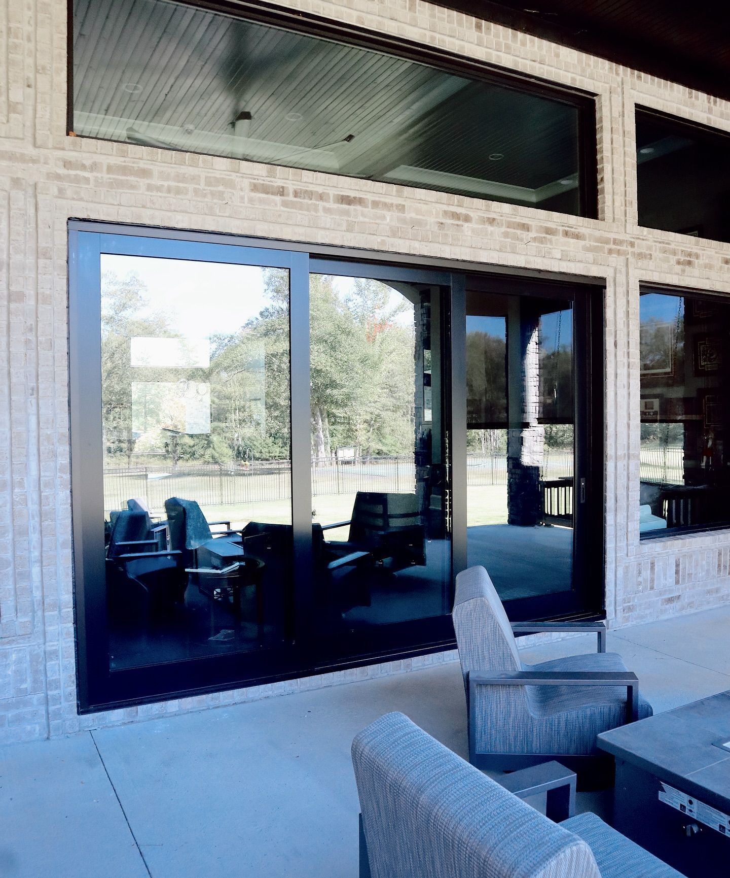 A patio with a lot of windows and chairs