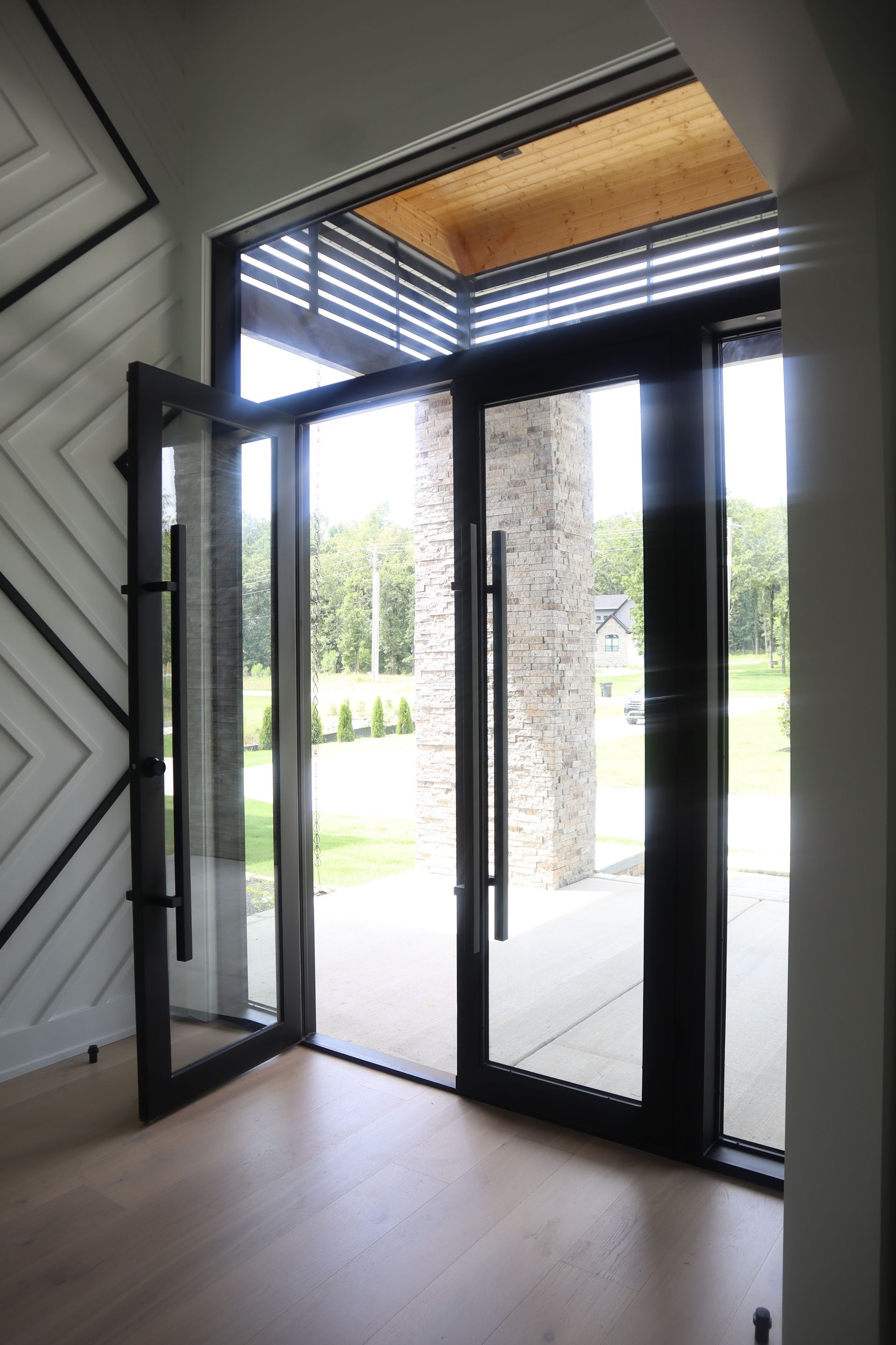 A room with a lot of windows and a door that is open