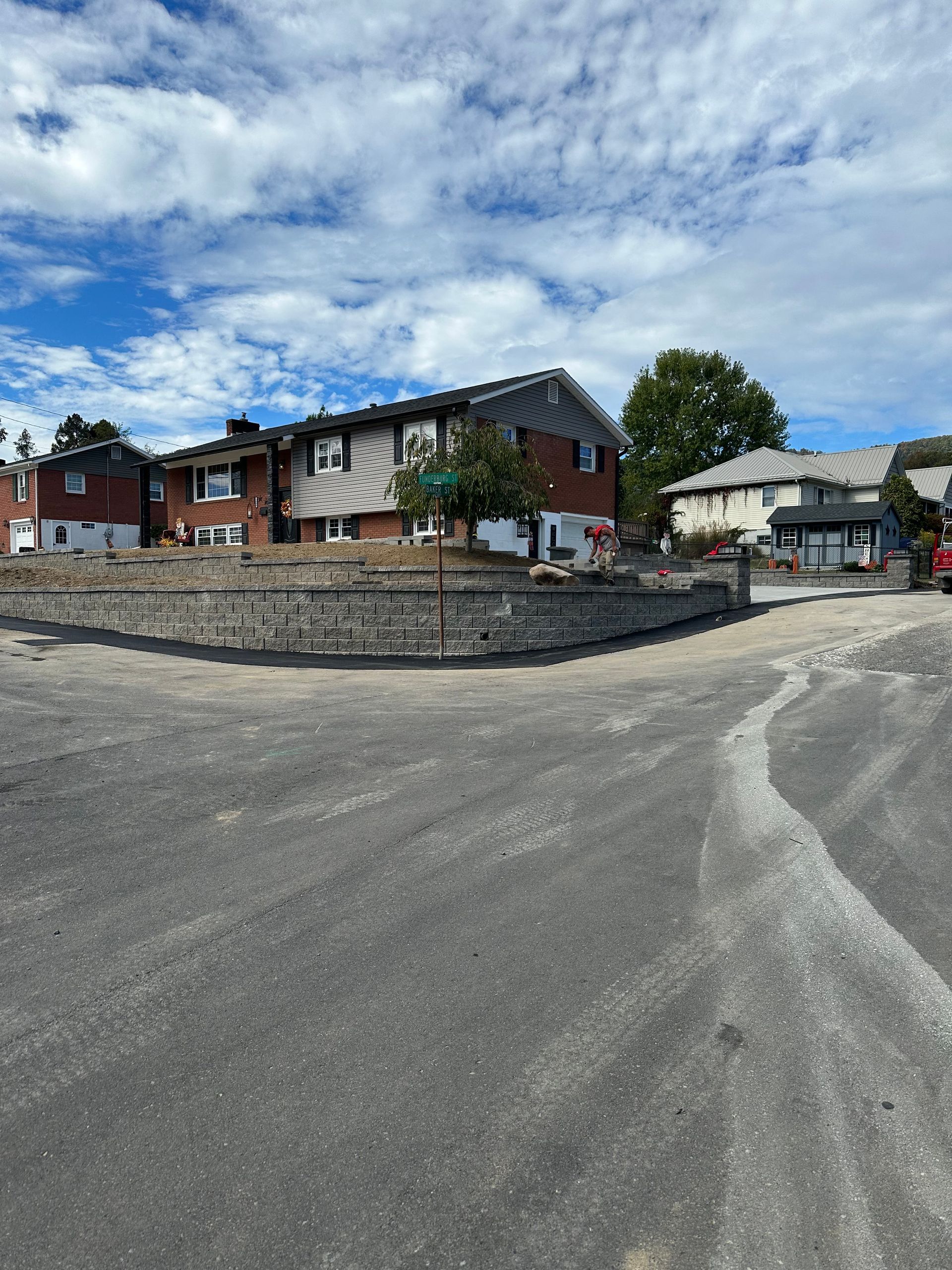 Townhouses on a sunny day with blue sky and white clouds. A paved road is in front.