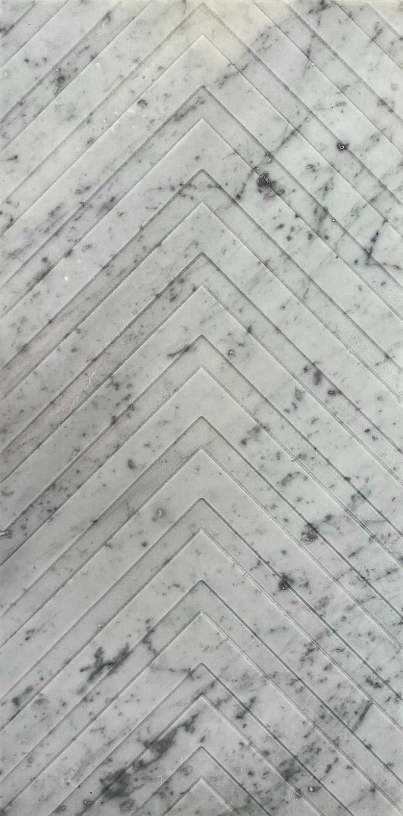 White marble surface with chevron pattern and dark grey veining.