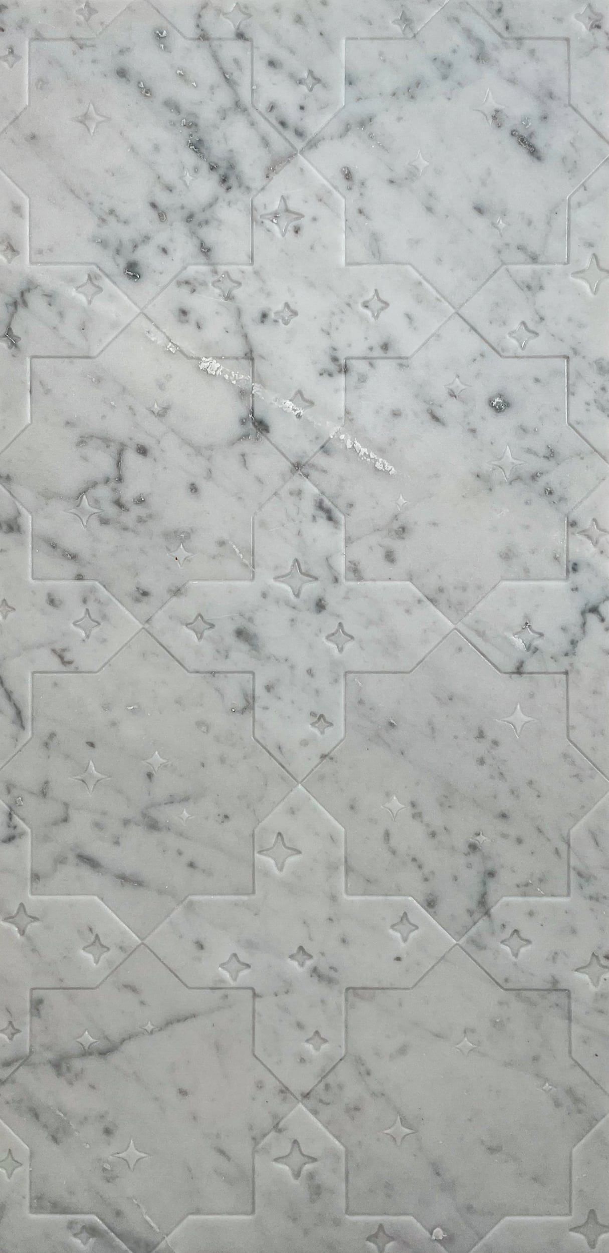 White marble tile with gray veining and a geometric pattern.