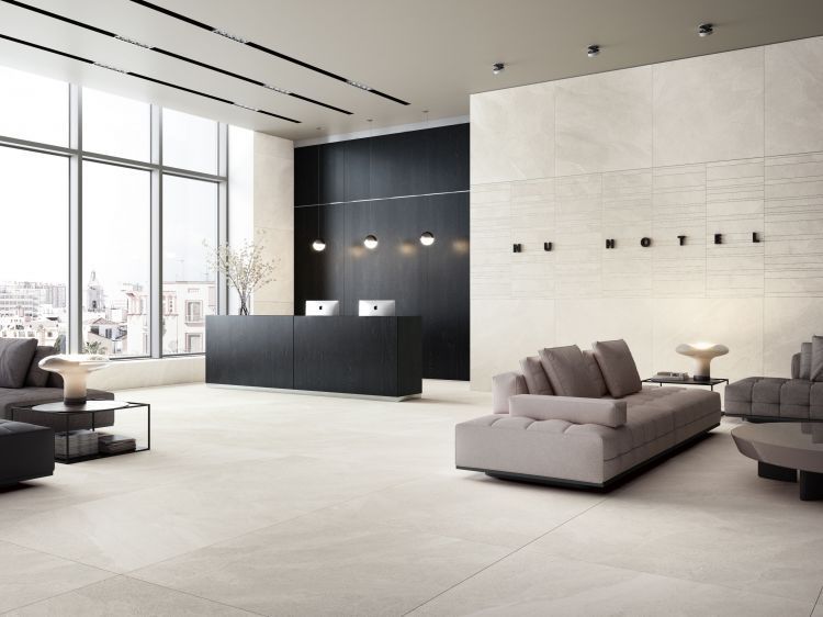 Modern lobby with a black reception desk, gray couches, and large windows.