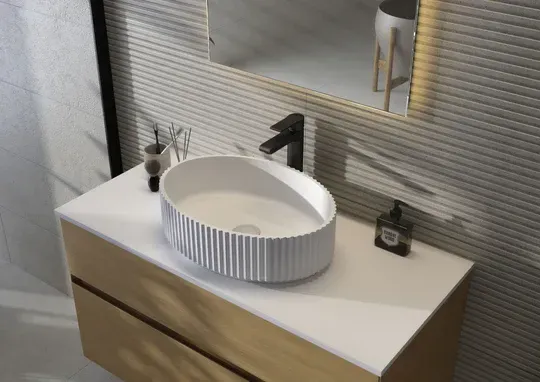 Bathroom vanity with a white, textured oval sink, black faucet, and a wood cabinet.