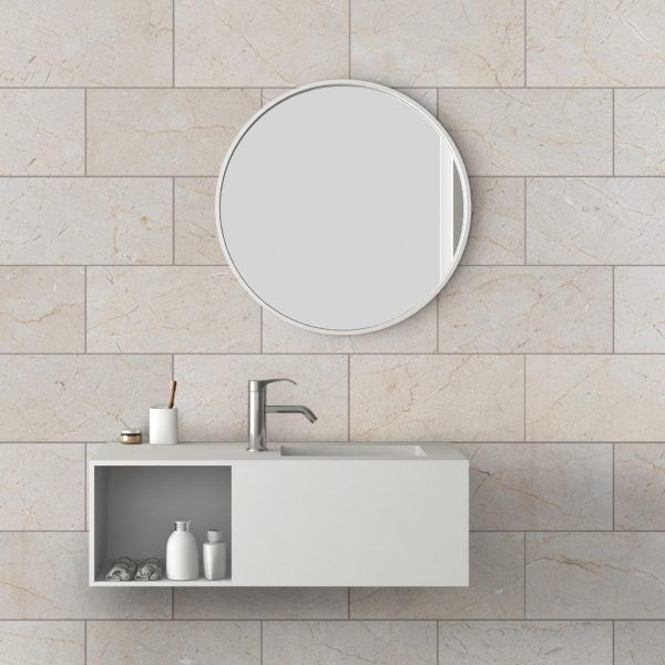 White modern bathroom vanity with round mirror on tiled wall.