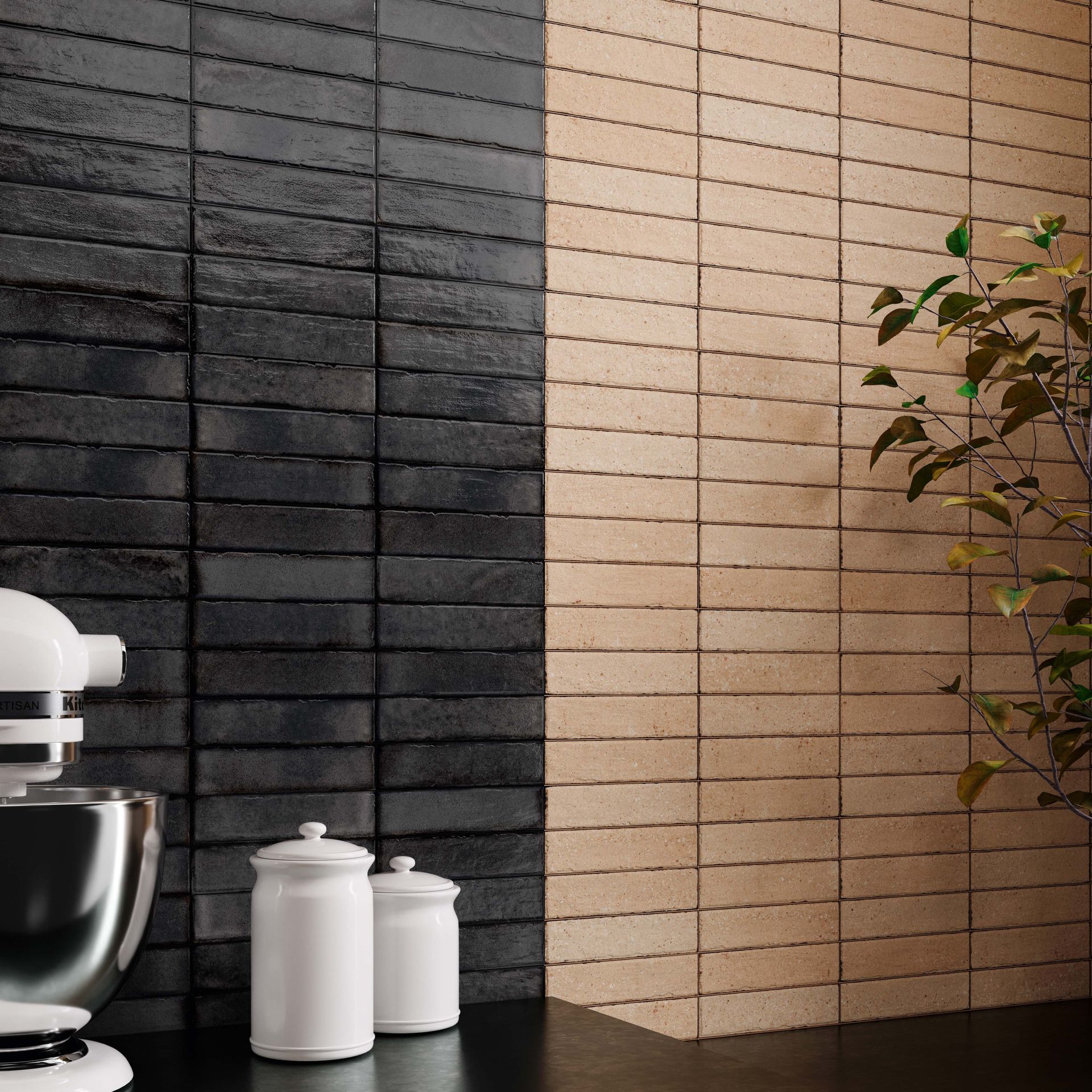 Kitchen wall with black and tan brick-like tiles, white mixer, canisters, and leafy branch.