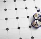 White and black tiled floor with dark diamond-shaped accents, partially visible with decorative blue jars.