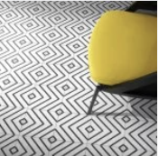 Yellow chair against a patterned floor. Black and white geometric squares.