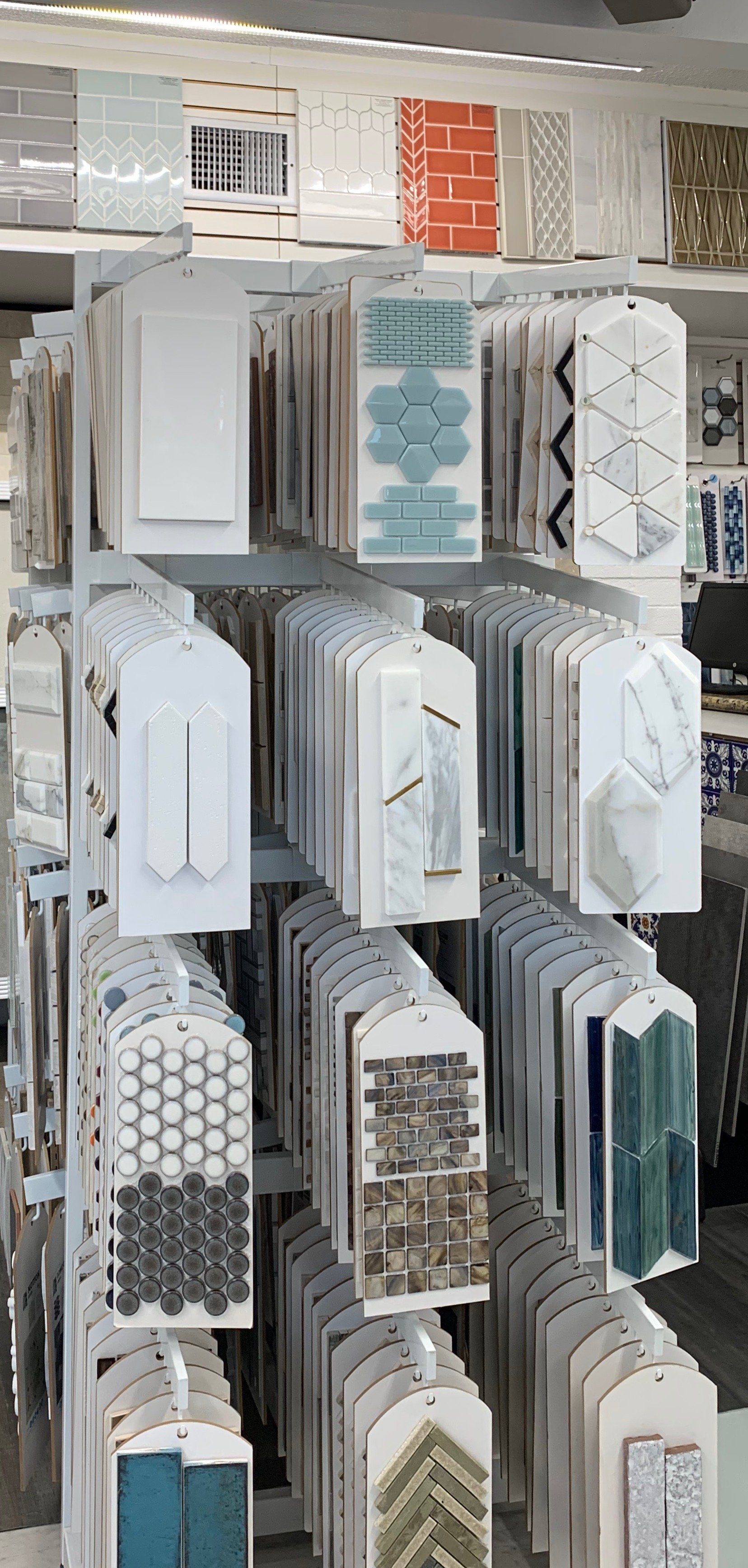 A tile display rack showcasing various tile samples with different colors, patterns, and shapes.