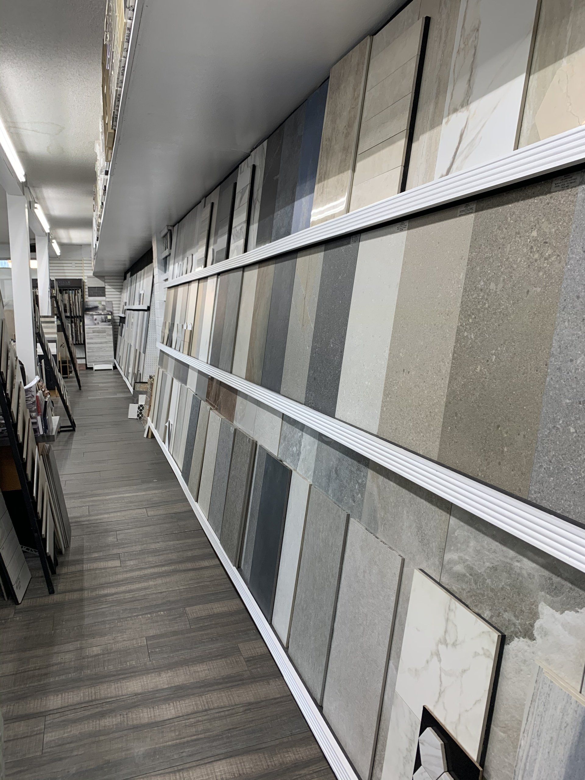 Tiles displayed on shelves in a showroom, showcasing various colors and textures.