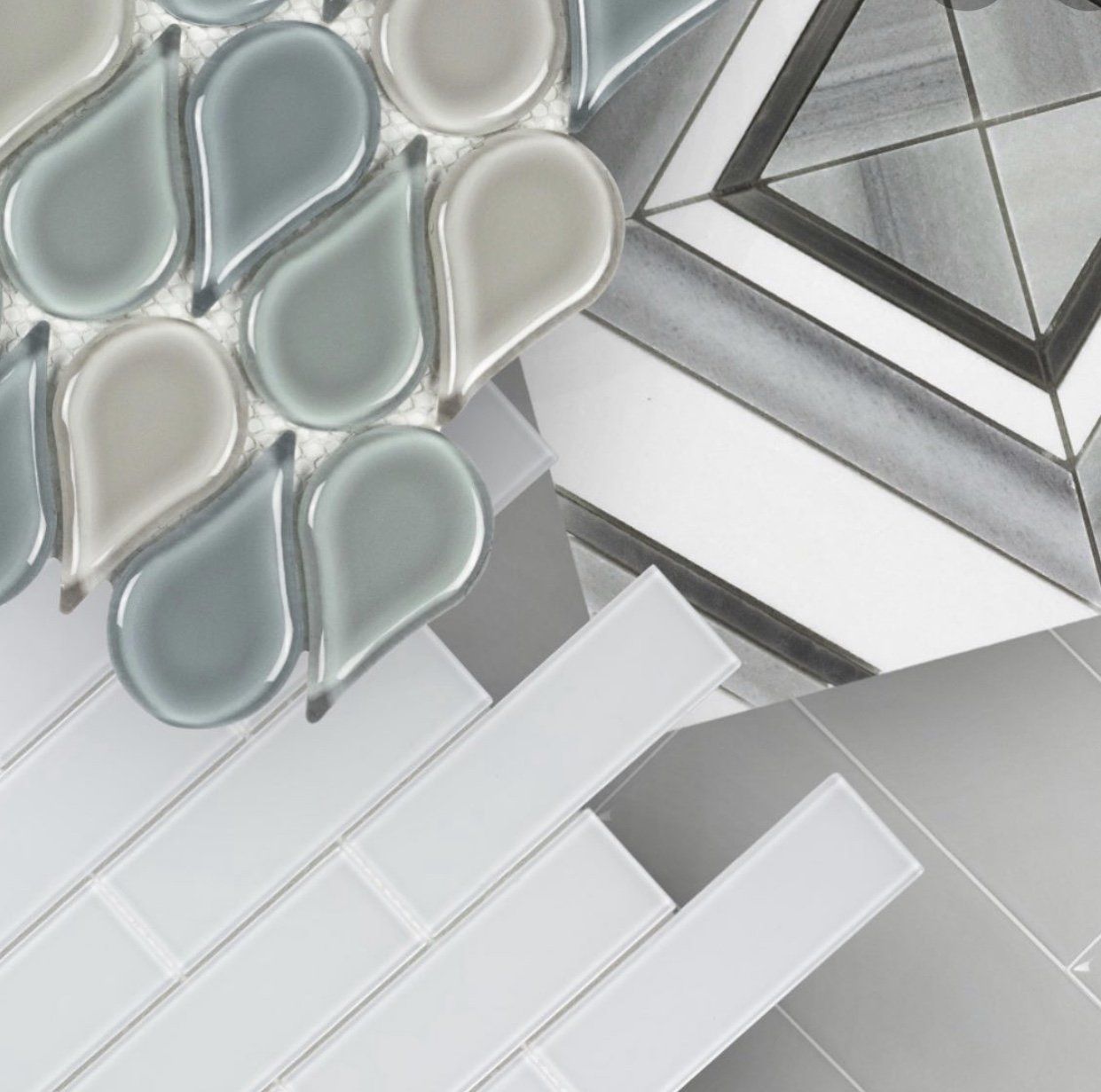 Assortment of mosaic tiles in shades of blue, gray, and white. Various shapes, including teardrops and rectangles.
