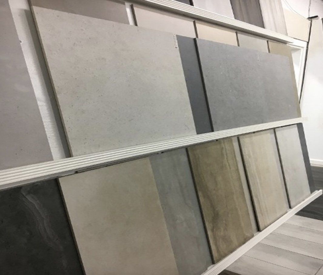 Display of various neutral-colored tile samples on shelves.