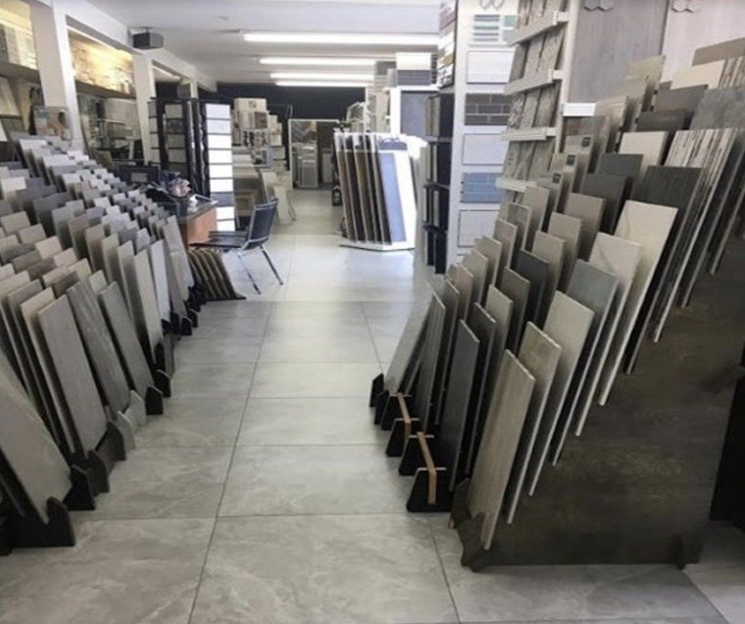 Tile showroom with various tile samples displayed on racks.