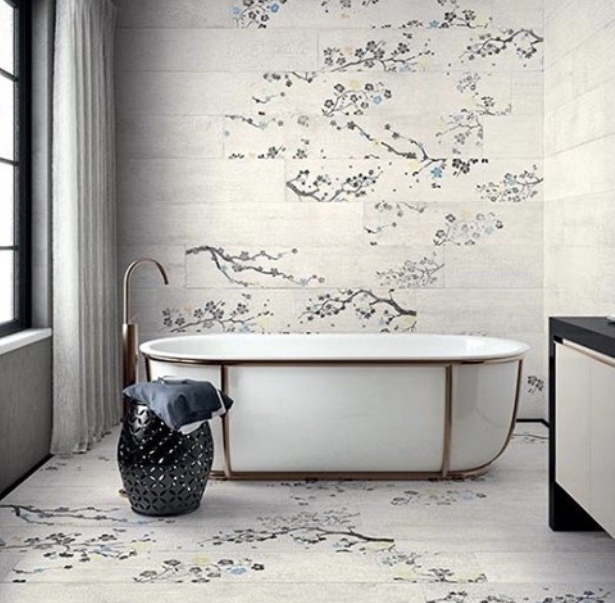 Bathroom with floral tile, freestanding tub, and black accents.