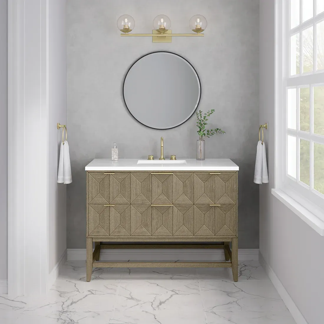 Bathroom with a wood vanity, round mirror, and gold accents; towels hang on either side.