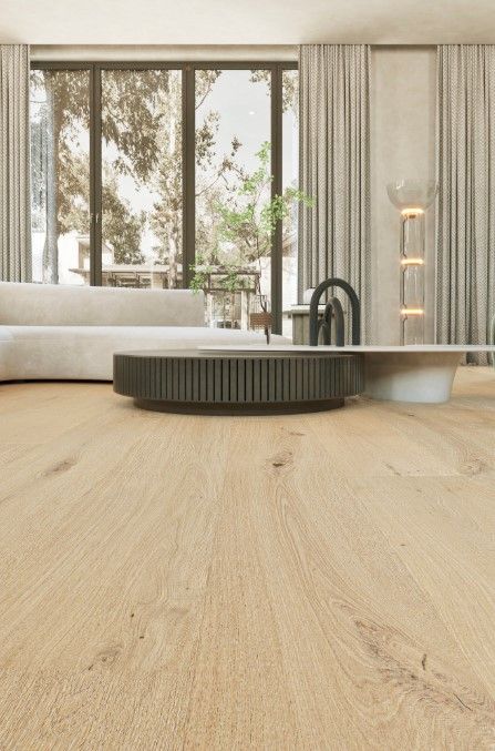 Living room with light wood floors, large windows, and modern furniture.