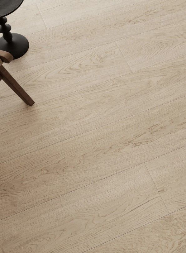 Light wood-grain flooring with a portion of a black chair and table leg in the upper left corner.