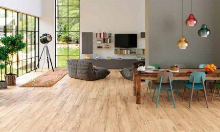 Modern living room with wood floors, large windows, and a dining table with colorful chairs.