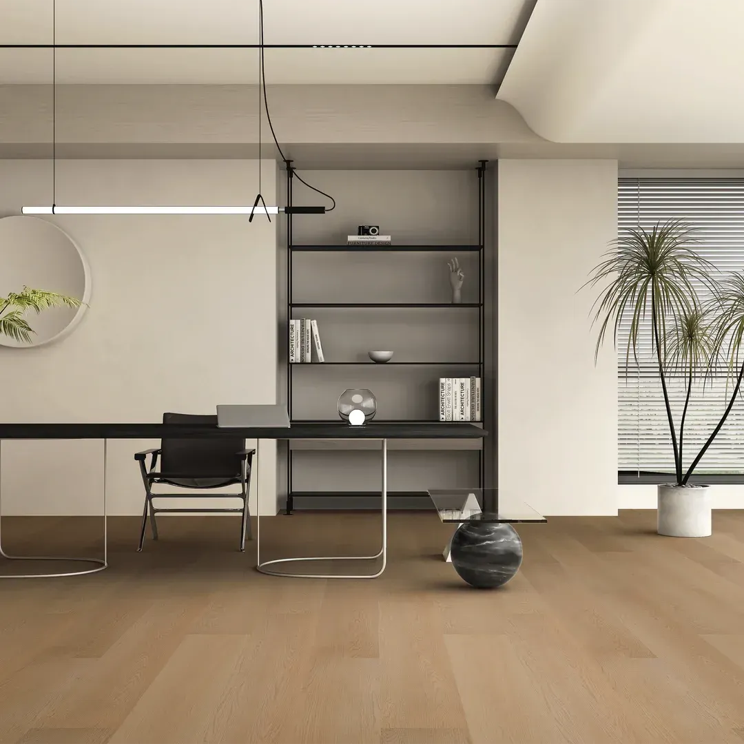 Office with a desk, bookshelf, chair, and plant on light-brown wood flooring. Minimalist design.