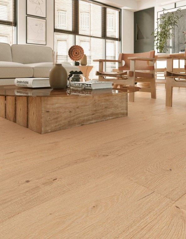 Living room with light wood floors, a sofa, wooden chairs, and a coffee table.