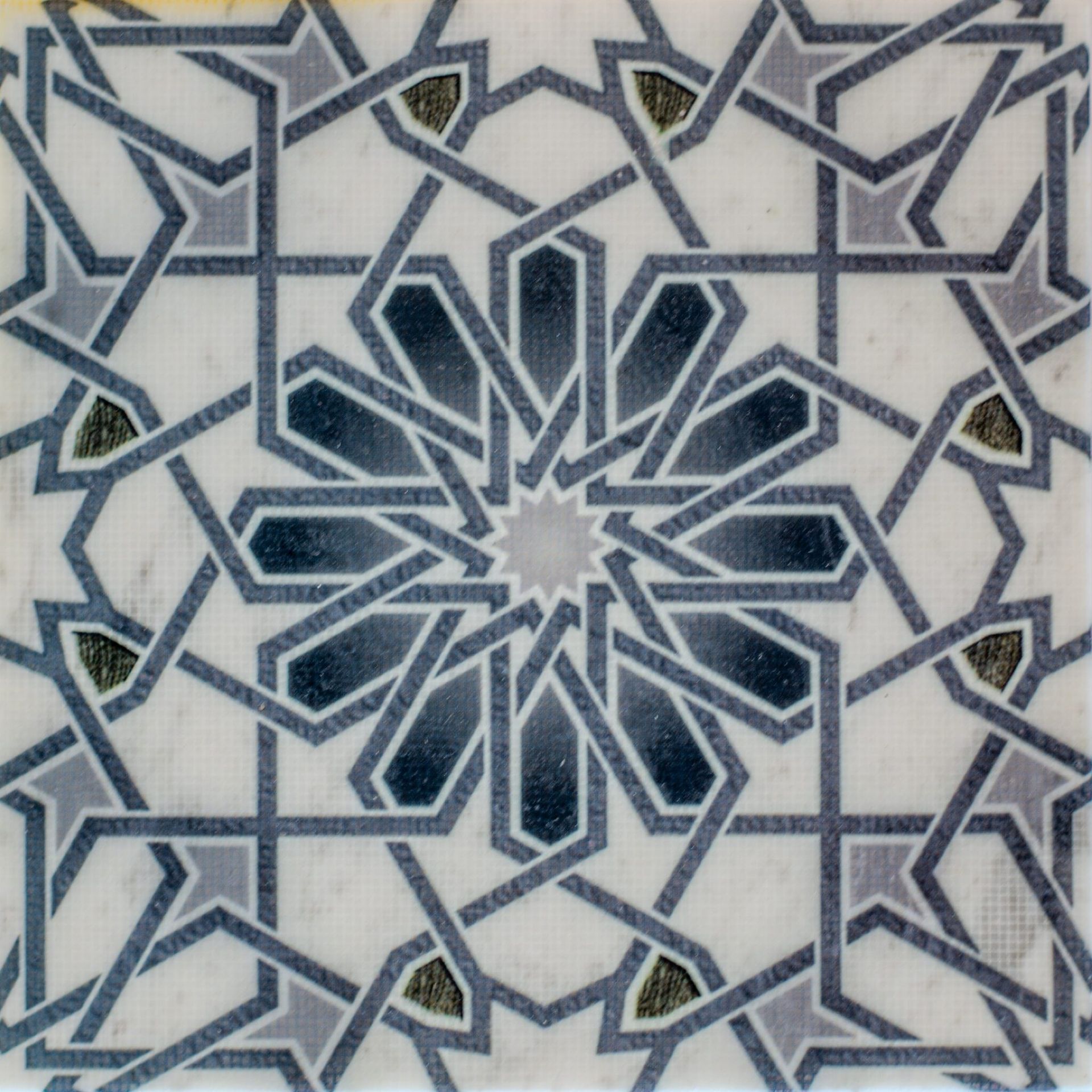 Geometric tile with complex interlacing blue and grey star-shaped patterns on a white background.