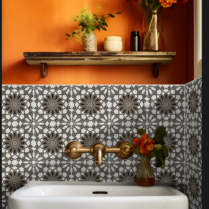 Bathroom with decorative patterned tile, gold fixtures, orange wall, and shelf with vases.