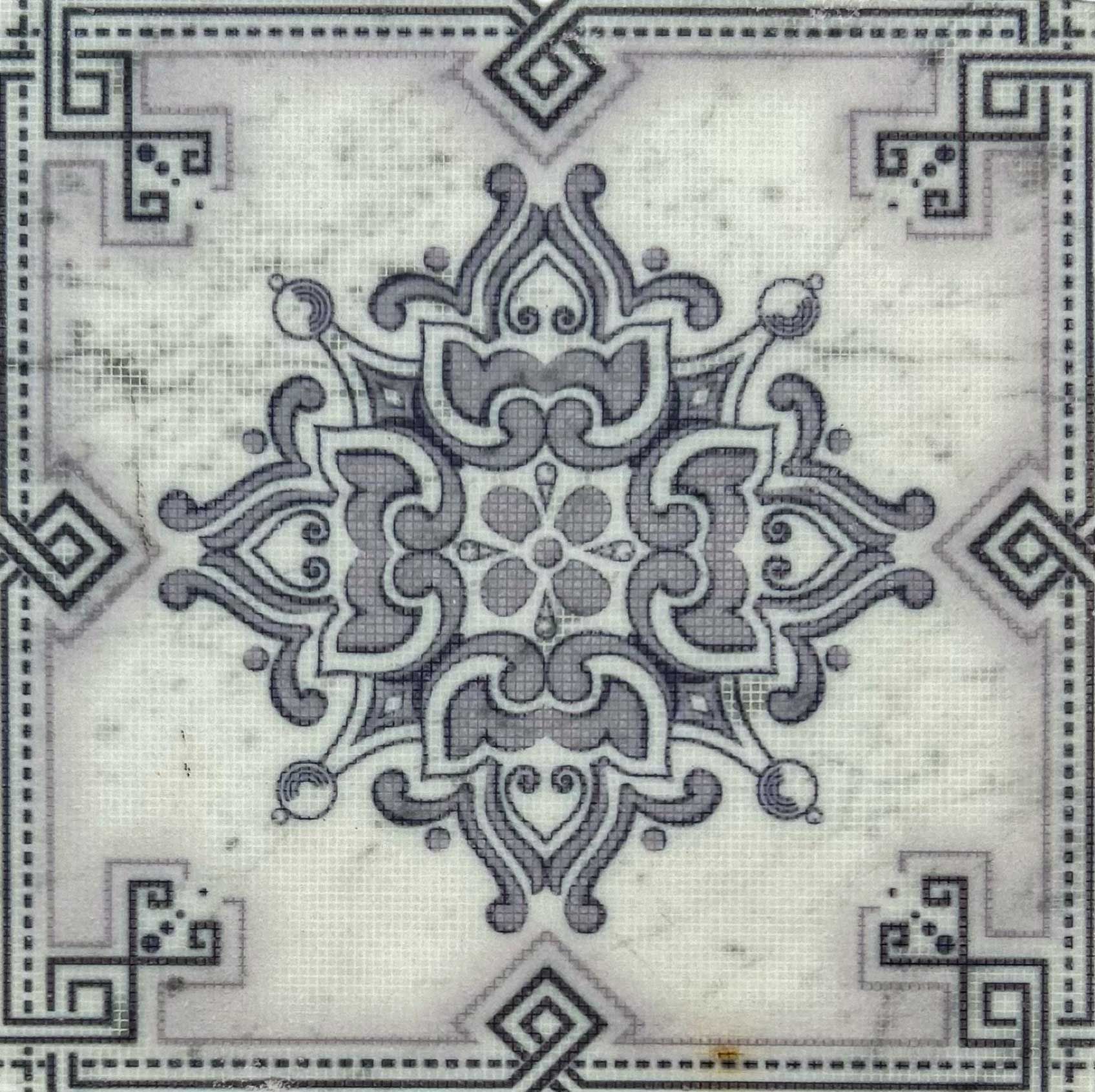 Gray and white patterned tile with ornate central design and border elements.