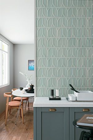 Kitchen with teal-tiled wall, white countertop, and gray cabinets. Wooden chairs and a round table are visible.