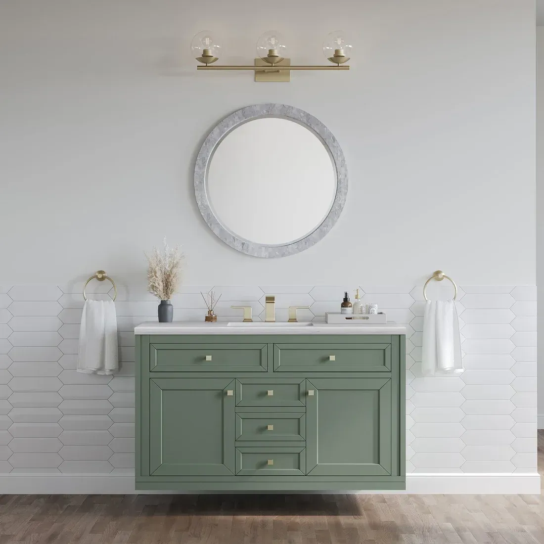 Green bathroom vanity with marble countertop, round mirror, and gold accents.