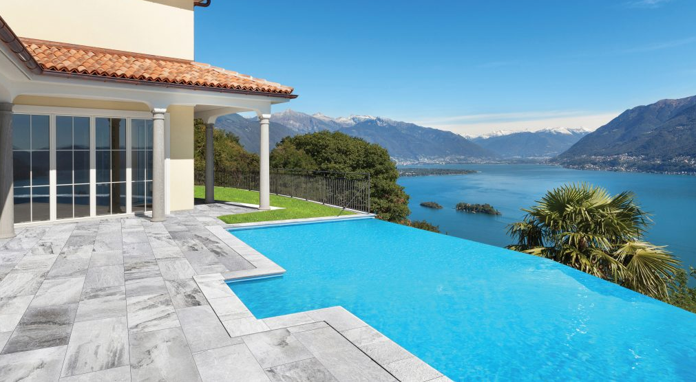 picture of outdoor pool in back yard showing porcelain pavers around the pool