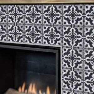 Fireplace with black and white patterned tiles.