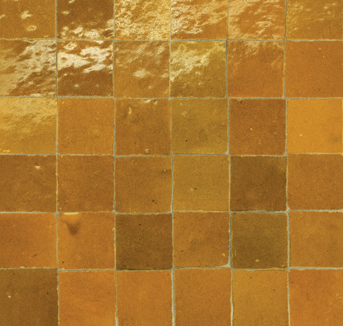 Square tiles in shades of brown and gold, creating a textured surface.