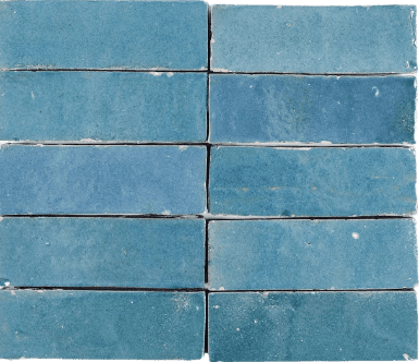 'Elongated 2x6 brick-shaped Zellige tiles in a delicate, sky-blue shade. These handmade tiles exhibit a glossy, textured surface, showcasing subtle variations in tone and texture, evoking a serene and calming aesthetic.'