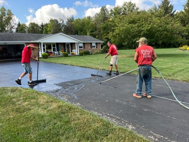 Riley's Sealcoating team working on a driveway