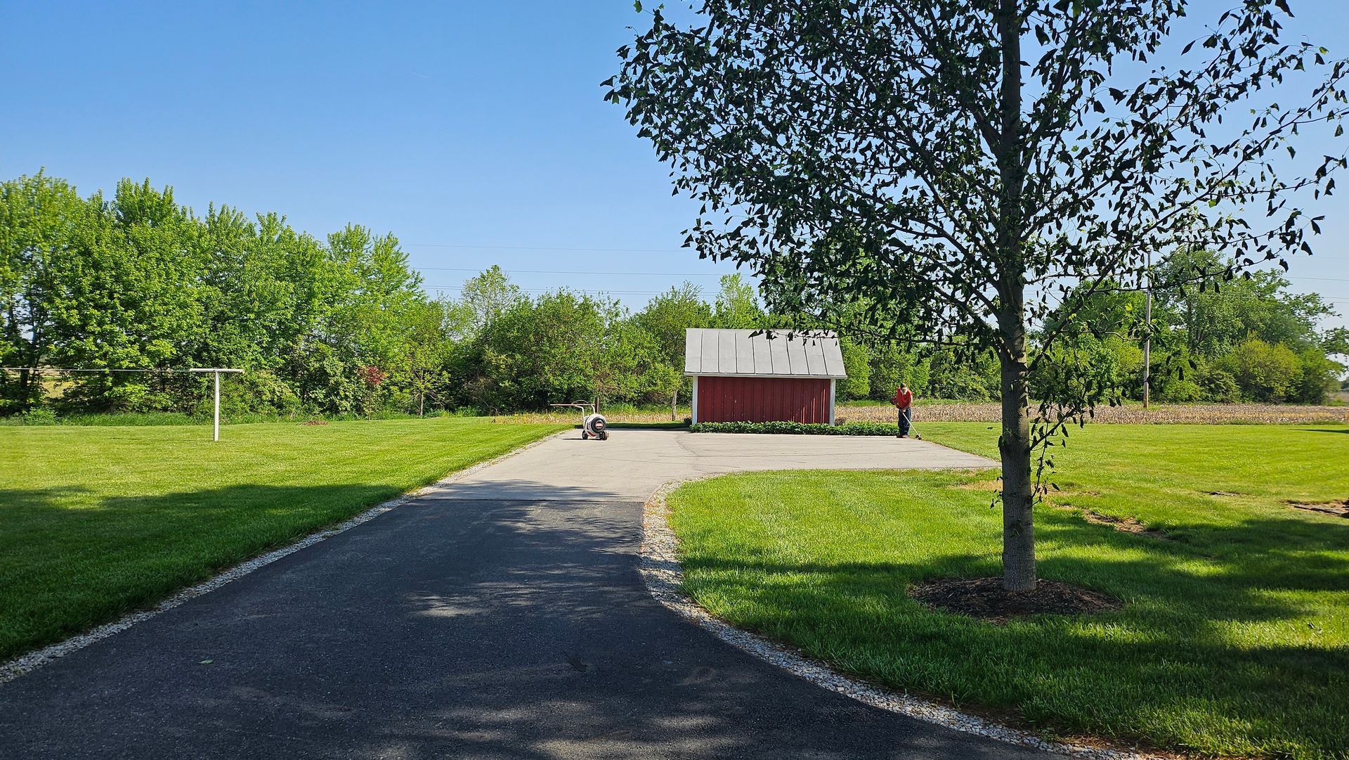 A red barn is in the middle of a grassy field
