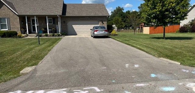 A car is parked in the driveway of a house.