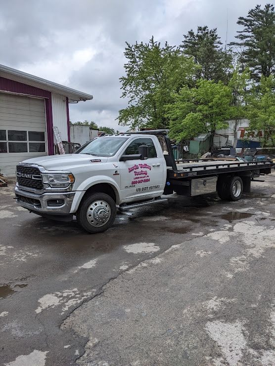 White tow truck parked outside a building on an overcast day.