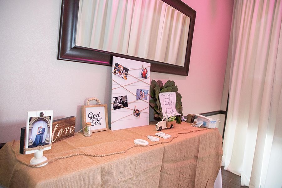 Wedding decor: Burlap-covered table with photos, cards, and a mirror on the wall.