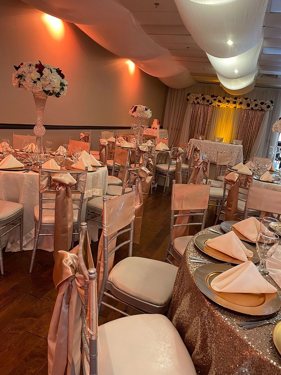 Elegant banquet hall with decorated tables and chairs, soft lighting, and floral centerpieces.