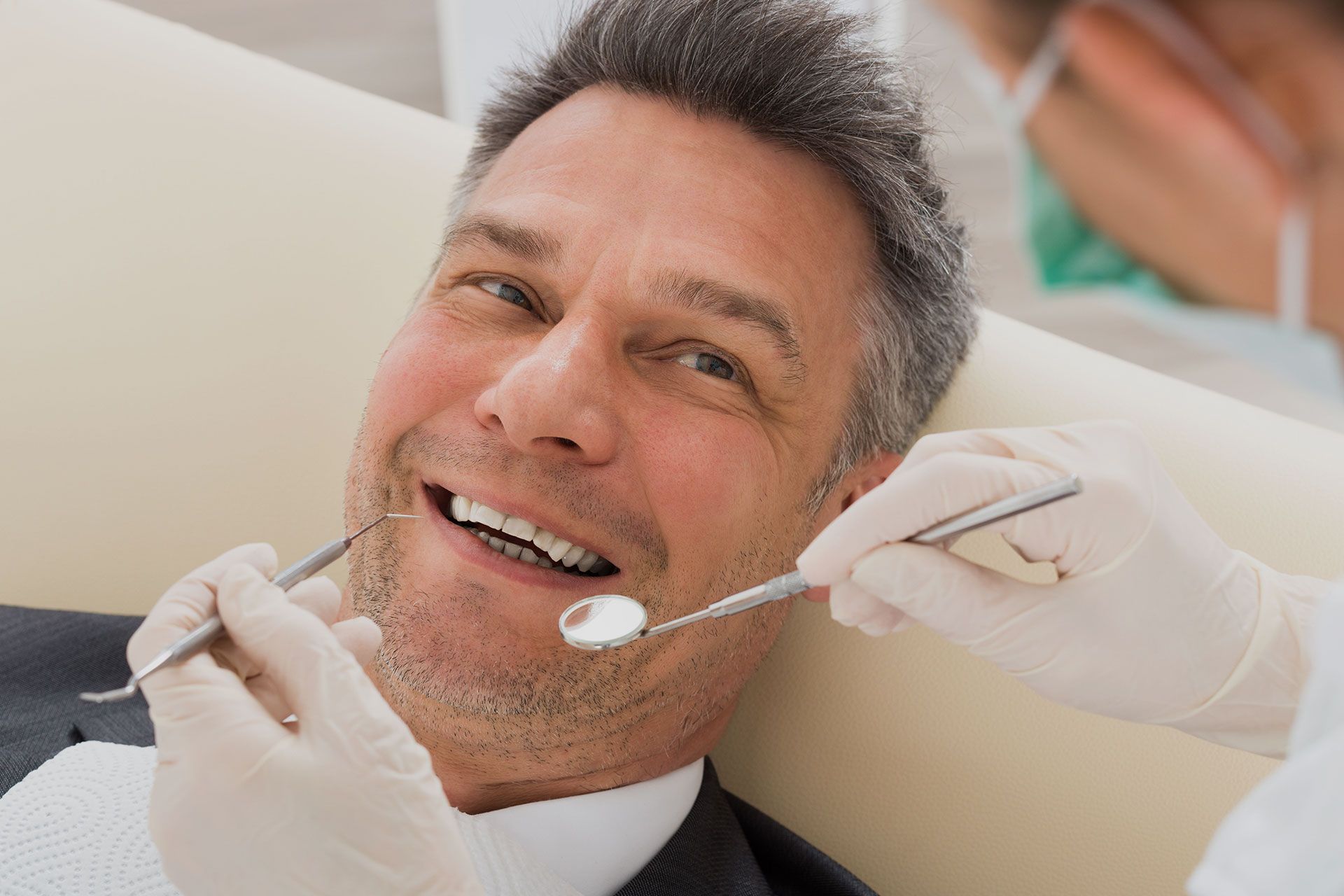 A man is having his teeth examined by a dentist.