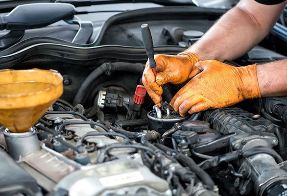 A man is working on the engine of a car.