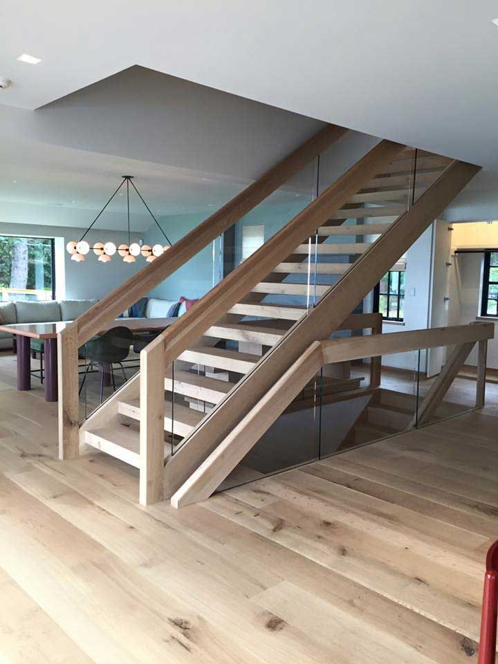 Wooden staircase with glass panels. Light wood floors and ceiling.