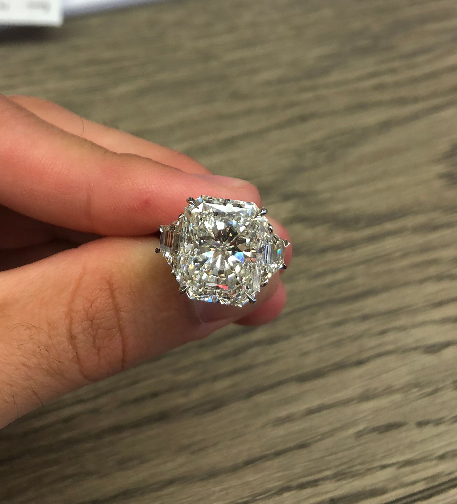 A person is holding a diamond ring in their hand