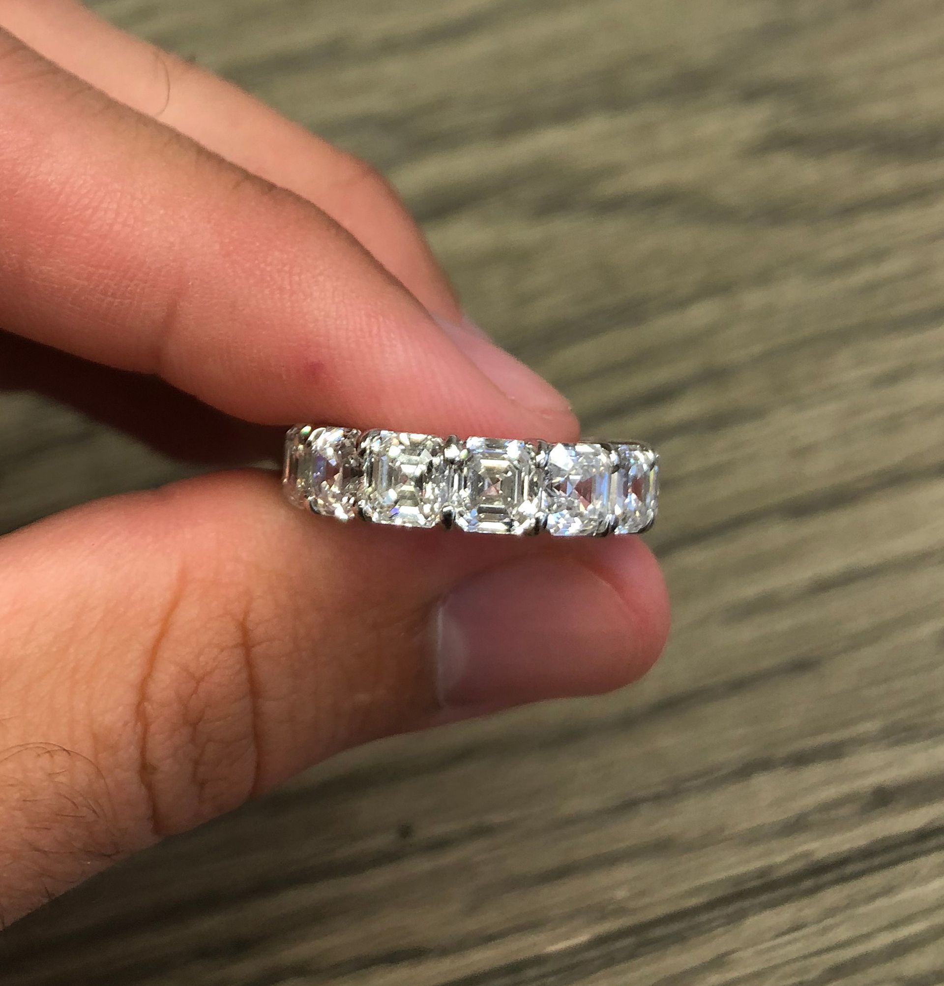 A person is holding a diamond ring in their hand